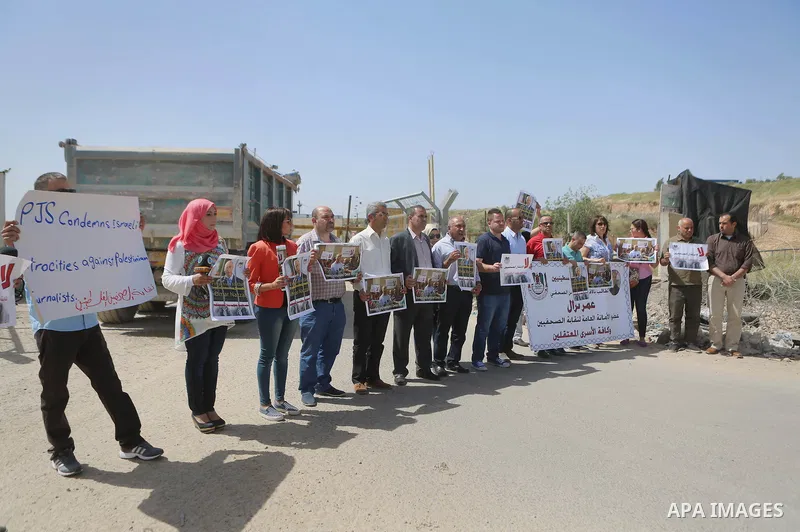 Palestinian journalists hold banners during a protest calling for the release of Palestinian journalist Omar Nazal, who is held by Israel, near Israel's Ofer Prison near the West Bank city of Ramallah April 26, 2016. Pho...