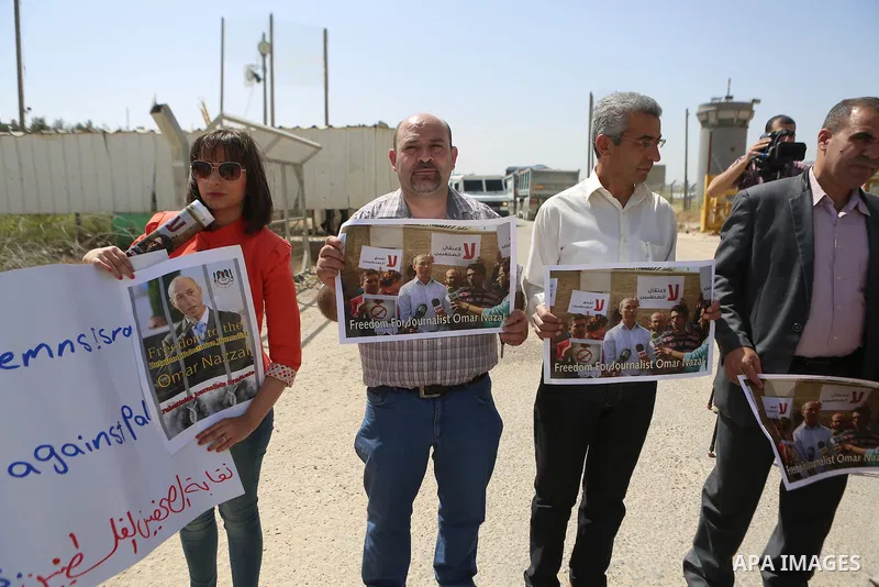 Palestinian journalists hold banners during a protest calling for the release of Palestinian journalist Omar Nazal, who is held by Israel, near Israel's Ofer Prison near the West Bank city of Ramallah April 26, 2016. Pho...