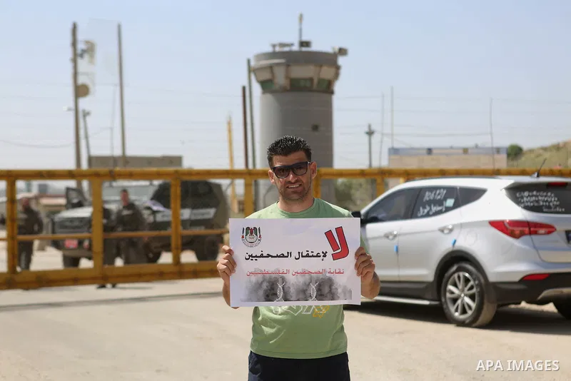 Palestinian journalists hold banners during a protest calling for the release of Palestinian journalist Omar Nazal, who is held by Israel, near Israel's Ofer Prison near the West Bank city of Ramallah April 26, 2016. Pho...