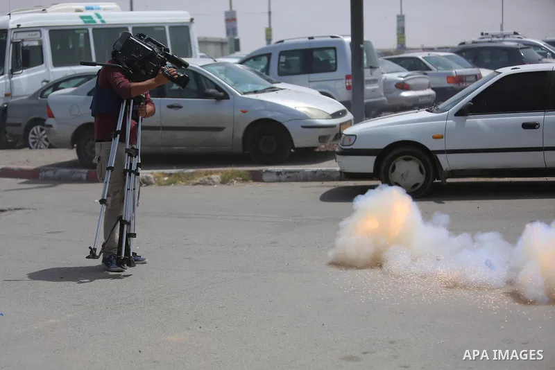 A Palestinian camera man takes a video at the Qalandia checkpoint, between Jerusalem and Ramallah in the Israeli occupied West Bank, after two Palestinians were shot as they approached security at the border carrying a k...