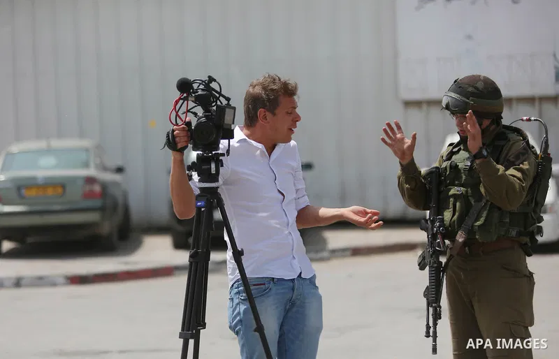 A Palestinian journalist argues by Israeli security forces at the Qalandia checkpoint, between Jerusalem and Ramallah in the Israeli occupied West Bank, after two Palestinians were shot as they approached security at the...