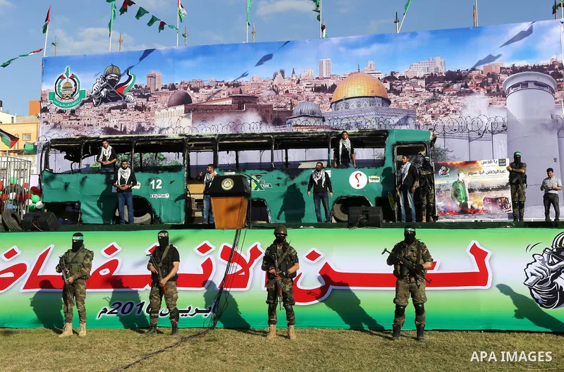 Palestinian Hamas militants march in front of a mock burnt Israeli bus during an anti-Israel rally in Gaza city April 28, 2016. Photo by Mohammed Asad