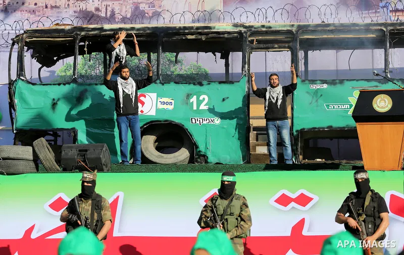 Palestinian Hamas militants march in front of a mock burnt Israeli bus during an anti-Israel rally in Gaza city April 28, 2016. Photo by Mohammed Asad