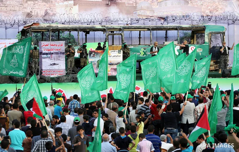 Palestinian Hamas militants march in front of a mock burnt Israeli bus during an anti-Israel rally in Gaza city April 28, 2016. Photo by Mohammed Asad