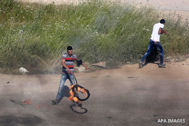 A Palestinian protester burns tires during clashes Israeli security forces on April 29, 2016, following a demonstration in solidarity with Palestinian prisoners held in Israeli jails, outside the compound of the Israeli-...