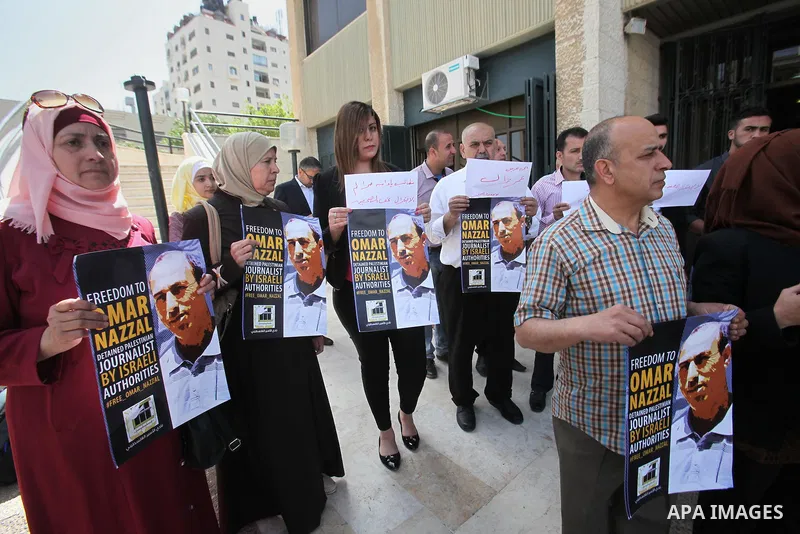 Palestinian journalists hold placards during a protest demanding release their colleague Omar Nazzal, in Israeli jail, in the West Bank city of Nablus, on April 30, 2016. Photo by Nedal Eshtayah