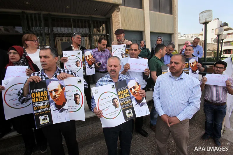 Palestinian journalists hold placards during a protest demanding release their colleague Omar Nazzal, in Israeli jail, in the West Bank city of Nablus, on April 30, 2016. Photo by Nedal Eshtayah