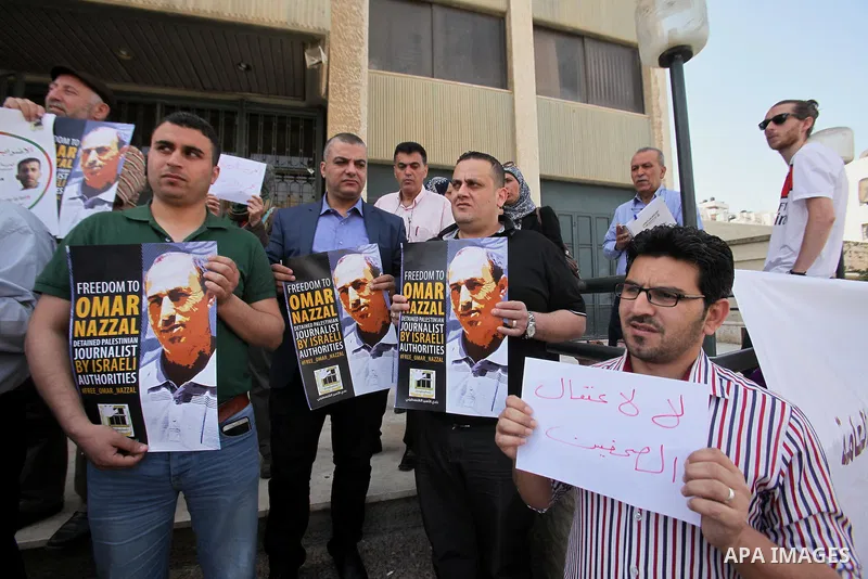 Palestinian journalists hold placards during a protest demanding release their colleague Omar Nazzal, in Israeli jail, in the West Bank city of Nablus, on April 30, 2016. Photo by Nedal Eshtayah