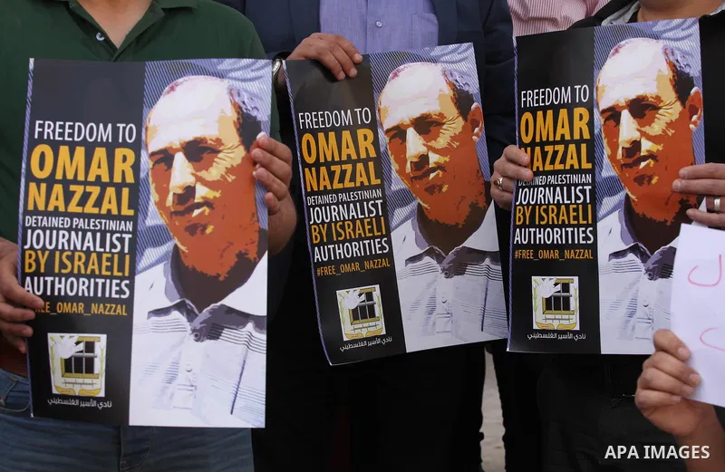 Palestinian journalists hold placards during a protest demanding release their colleague Omar Nazzal, in Israeli jail, in the West Bank city of Nablus, on April 30, 2016. Photo by Nedal Eshtayah