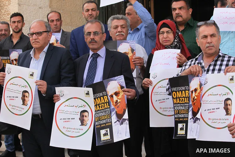 Palestinian journalists hold placards during a protest demanding release their colleague Omar Nazzal, in Israeli jail, in the West Bank city of Nablus, on April 30, 2016. Photo by Nedal Eshtayah