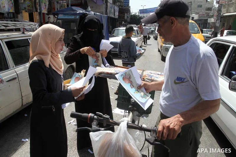 Palestinian women supporting Hamas movement distribute posters during awareness campaign against collaborate with Israel, in Rafah in southern Gaza strip, on April 30, 2016. Photo by Abed Rahim Khatib