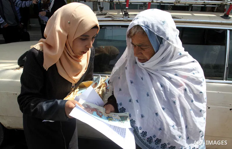 Palestinian women supporting Hamas movement distribute posters during awareness campaign against collaborate with Israel, in Rafah in southern Gaza strip, on April 30, 2016. Photo by Abed Rahim Khatib