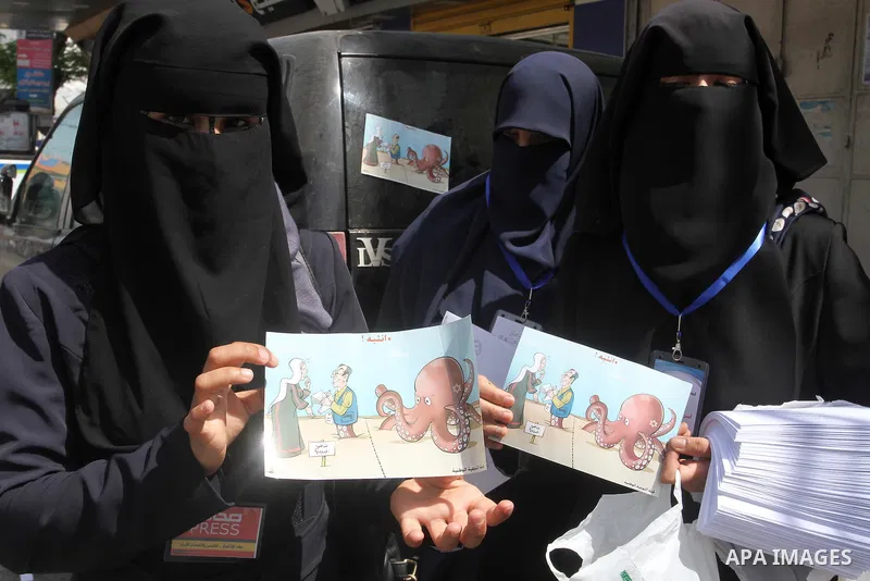 Palestinian women supporting Hamas movement distribute posters during awareness campaign against collaborate with Israel, in Rafah in southern Gaza strip, on April 30, 2016. Photo by Abed Rahim Khatib
