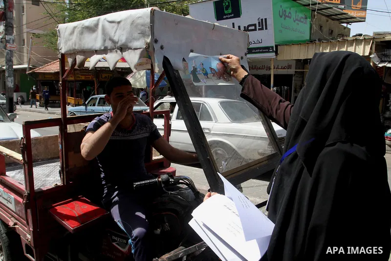 Palestinian women supporting Hamas movement distribute posters during awareness campaign against collaborate with Israel, in Rafah in southern Gaza strip, on April 30, 2016. Photo by Abed Rahim Khatib