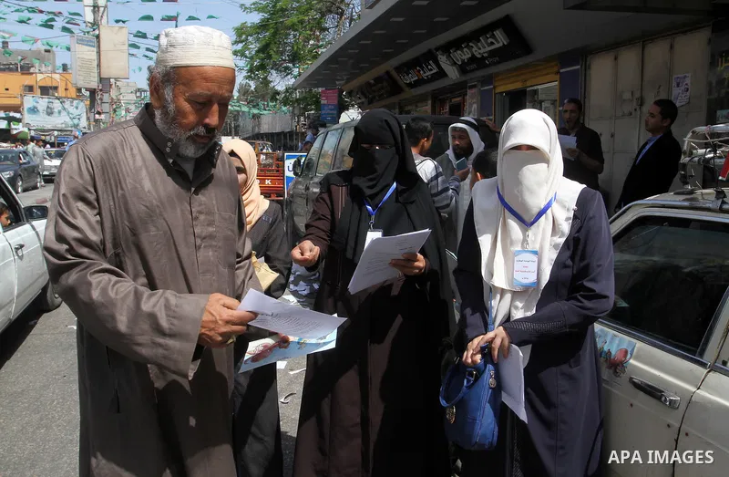 Palestinian women supporting Hamas movement distribute posters during awareness campaign against collaborate with Israel, in Rafah in southern Gaza strip, on April 30, 2016. Photo by Abed Rahim Khatib