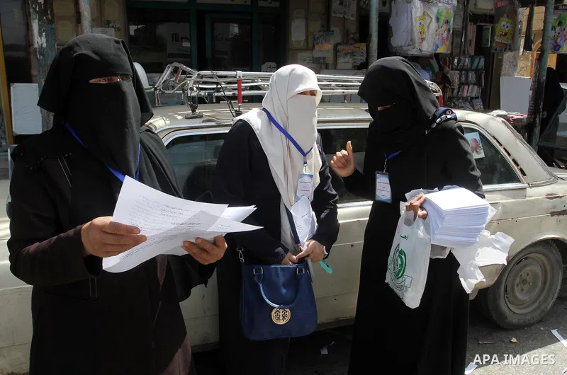 Palestinian women supporting Hamas movement distribute posters during awareness campaign against collaborate with Israel, in Rafah in southern Gaza strip, on April 30, 2016. Photo by Abed Rahim Khatib