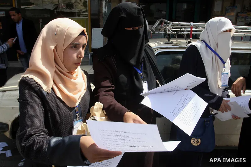Palestinian women supporting Hamas movement distribute posters during awareness campaign against collaborate with Israel, in Rafah in southern Gaza strip, on April 30, 2016. Photo by Abed Rahim Khatib