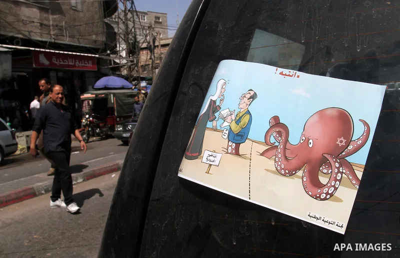 Palestinian women supporting Hamas movement distribute posters during awareness campaign against collaborate with Israel, in Rafah in southern Gaza strip, on April 30, 2016. Photo by Abed Rahim Khatib