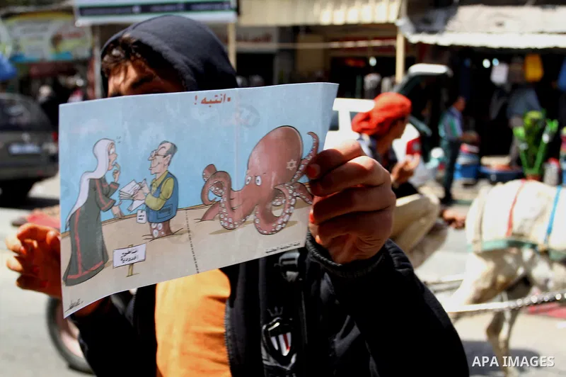 Palestinian women supporting Hamas movement distribute posters during awareness campaign against collaborate with Israel, in Rafah in southern Gaza strip, on April 30, 2016. Photo by Abed Rahim Khatib