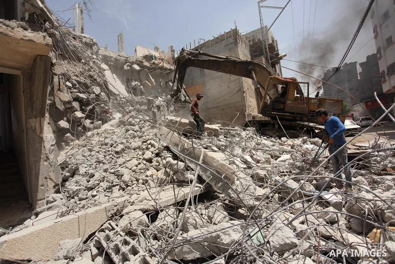 Palestinian men work on the remains of a building destroyed during the recent Israeli war 2014, in Shijaiyah neighborhood in the east of Gaza city, on April 30, 2016. Israel’s punitive ban on cement imports into the Gaza...