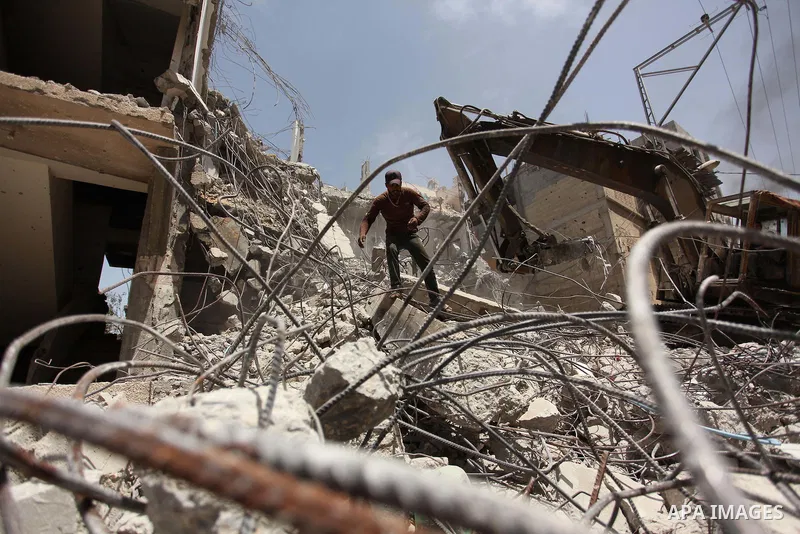 Palestinian men work on the remains of a building destroyed during the recent Israeli war 2014, in Shijaiyah neighborhood in the east of Gaza city, on April 30, 2016. Israel’s punitive ban on cement imports into the Gaza...