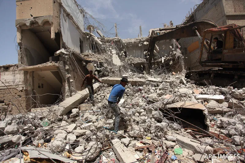 Palestinian men work on the remains of a building destroyed during the recent Israeli war 2014, in Shijaiyah neighborhood in the east of Gaza city, on April 30, 2016. Israel’s punitive ban on cement imports into the Gaza...