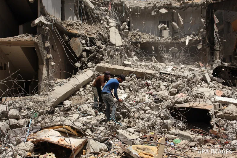 Palestinian men work on the remains of a building destroyed during the recent Israeli war 2014, in Shijaiyah neighborhood in the east of Gaza city, on April 30, 2016. Israel’s punitive ban on cement imports into the Gaza...