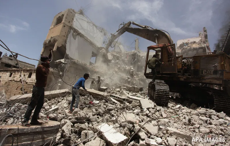 Palestinian men work on the remains of a building destroyed during the recent Israeli war 2014, in Shijaiyah neighborhood in the east of Gaza city, on April 30, 2016. Israel’s punitive ban on cement imports into the Gaza...
