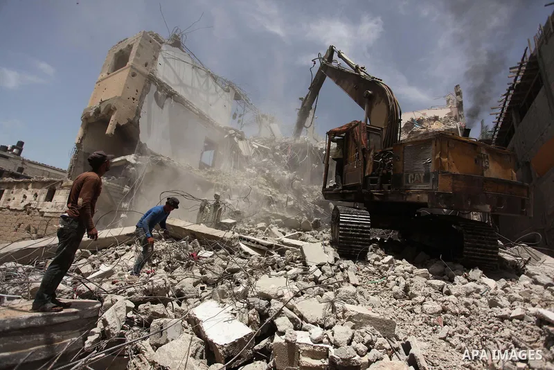Palestinian men work on the remains of a building destroyed during the recent Israeli war 2014, in Shijaiyah neighborhood in the east of Gaza city, on April 30, 2016. Israel’s punitive ban on cement imports into the Gaza...