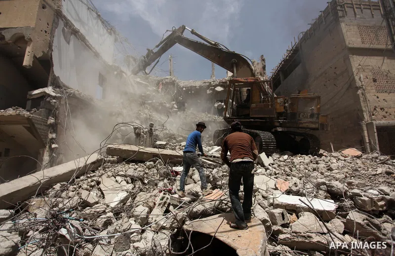 Palestinian men work on the remains of a building destroyed during the recent Israeli war 2014, in Shijaiyah neighborhood in the east of Gaza city, on April 30, 2016. Israel’s punitive ban on cement imports into the Gaza...