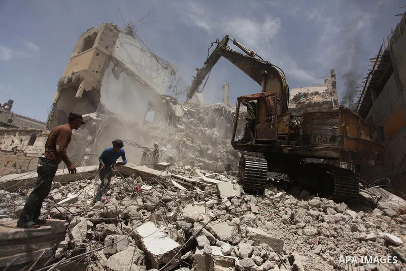 Palestinian men work on the remains of a building destroyed during the recent Israeli war 2014, in Shijaiyah neighborhood in the east of Gaza city, on April 30, 2016. Israel’s punitive ban on cement imports into the Gaza...