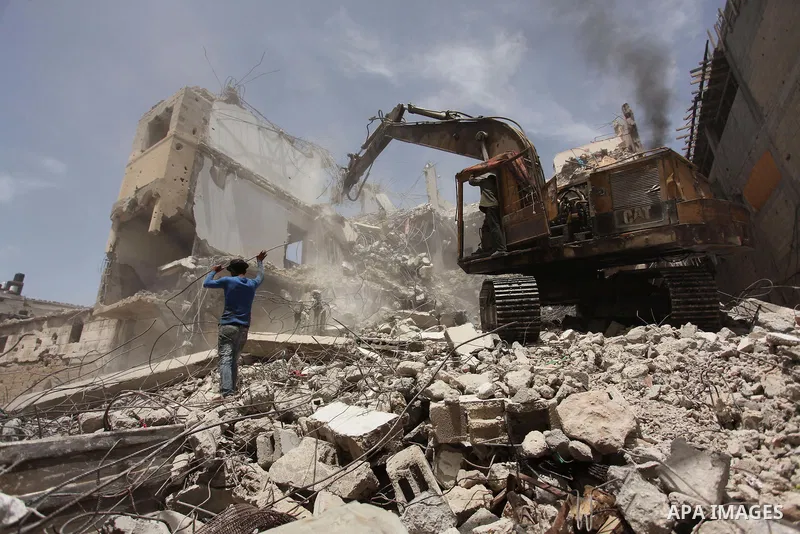 Palestinian men work on the remains of a building destroyed during the recent Israeli war 2014, in Shijaiyah neighborhood in the east of Gaza city, on April 30, 2016. Israel’s punitive ban on cement imports into the Gaza...