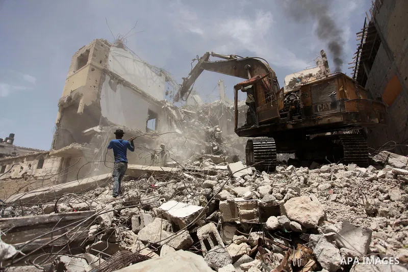 Palestinian men work on the remains of a building destroyed during the recent Israeli war 2014, in Shijaiyah neighborhood in the east of Gaza city, on April 30, 2016. Israel’s punitive ban on cement imports into the Gaza...