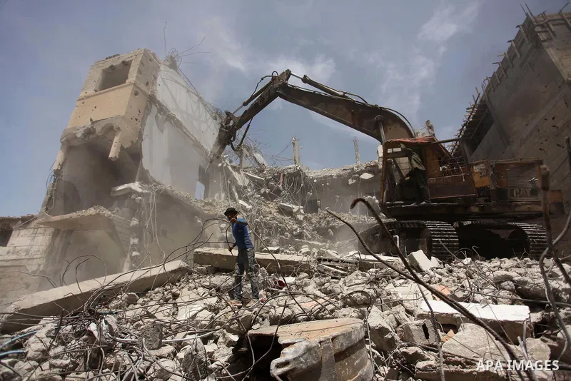 Palestinian men work on the remains of a building destroyed during the recent Israeli war 2014, in Shijaiyah neighborhood in the east of Gaza city, on April 30, 2016. Israel’s punitive ban on cement imports into the Gaza...