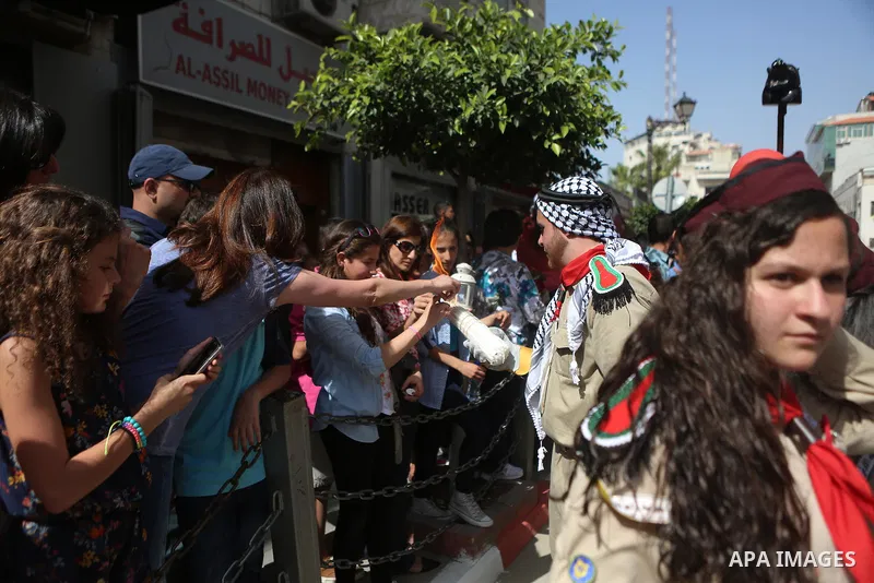 Palestinian christians march in the traditional Sabt al-Nour parade, in the West Bank city of Ramallah, on April 30, 2016. The Holy Fire is described by Orthodox Christians as a miracle that occurs every year at the Chur...