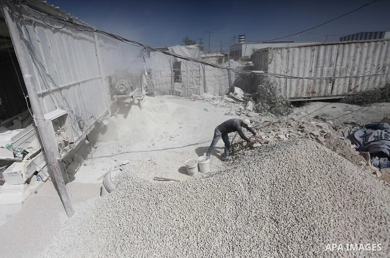 Palestinian workers crush stones and cement blocks from houses destroyed by Israeli shelling during the 50-day Israeli war in the summer of 2014, during the Workers' Day, in Gaza city, on May, 1, 2016. Photo by Mohammed...