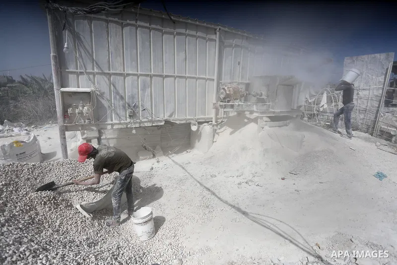 Palestinian workers crush stones and cement blocks from houses destroyed by Israeli shelling during the 50-day Israeli war in the summer of 2014, during the Workers' Day, in Gaza city, on May, 1, 2016. Photo by Mohammed...