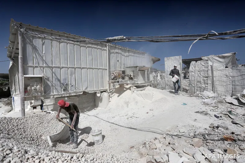 Palestinian workers crush stones and cement blocks from houses destroyed by Israeli shelling during the 50-day Israeli war in the summer of 2014, during the Workers' Day, in Gaza city, on May, 1, 2016. Photo by Mohammed...