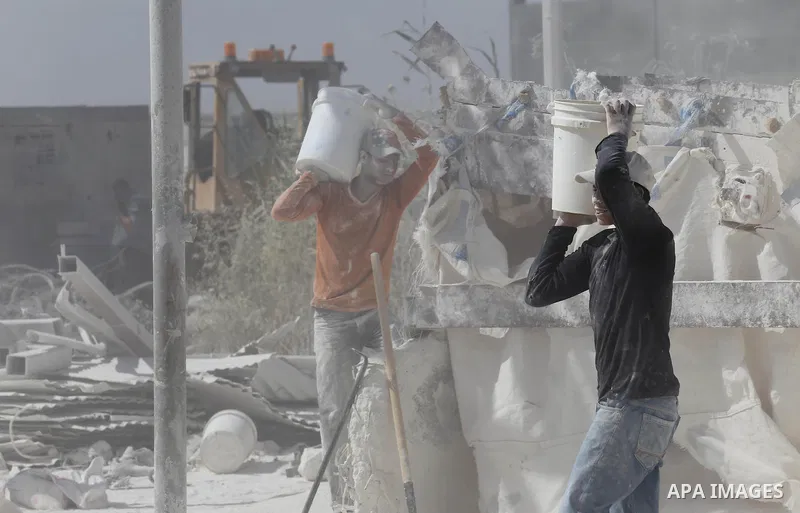 Palestinian workers crush stones and cement blocks from houses destroyed by Israeli shelling during the 50-day Israeli war in the summer of 2014, during the Workers' Day, in Gaza city, on May, 1, 2016. Photo by Mohammed...