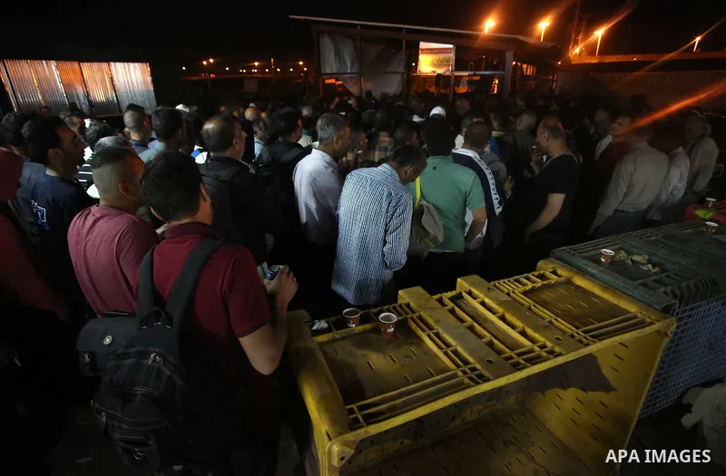 Palestinian labourers working in Israel wait to cross a checkpoint to go to work through the main Israeli terminal near the West Bank town of Qalqilya on International Workers' Day May 1, 2016. Photo by Stringer