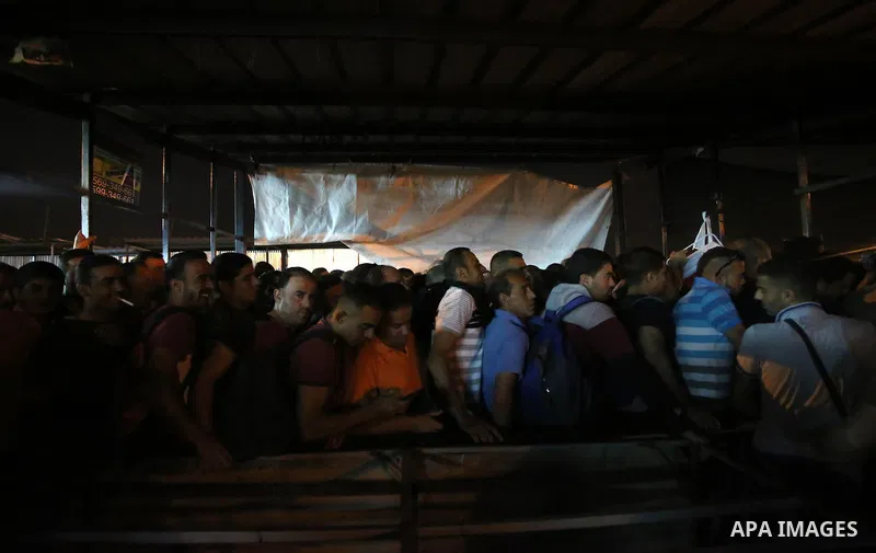 Palestinian labourers working in Israel wait to cross a checkpoint to go to work through the main Israeli terminal near the West Bank town of Qalqilya on International Workers' Day May 1, 2016. Photo by Stringer
