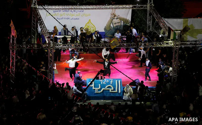 Palestinians take part in a opening ceremony of al-Hurria radio broadcasting office after the closure by the Israeli military, in the West Bank city of Hebron, on May 1, 2016. Photo by Wisam Hashlamoun