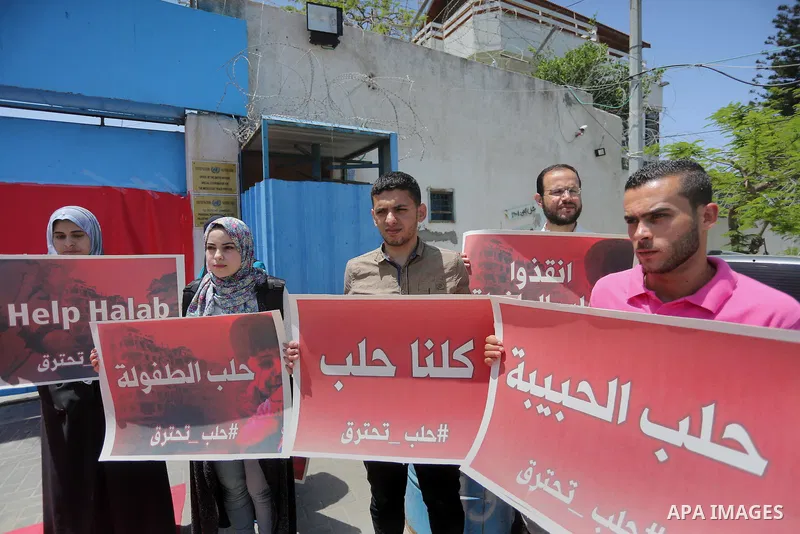 Palestinians hold placards during a rally against Syrian government shelling on the northern city of Aleppo, in front of the headquarter United Nation "UNSCO" in Gaza City, on May 2, 2016. Photo by Mohammed Asad