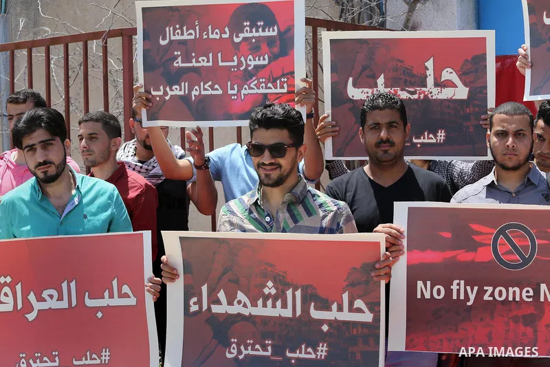 Palestinians hold placards during a rally against Syrian government shelling on the northern city of Aleppo, in front of the headquarter United Nation "UNSCO" in Gaza City, on May 2, 2016. Photo by Mohammed Asad