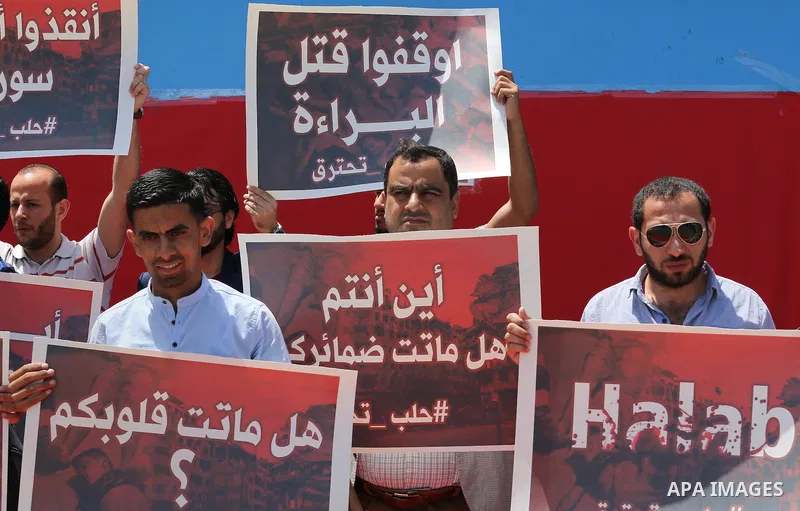 Palestinians hold placards during a rally against Syrian government shelling on the northern city of Aleppo, in front of the headquarter United Nation "UNSCO" in Gaza City, on May 2, 2016. Photo by Mohammed Asad