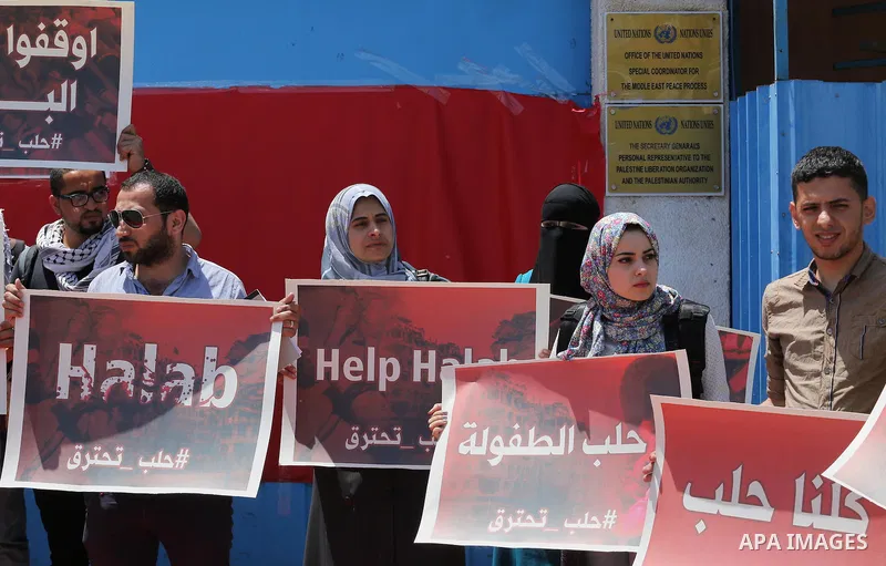 Palestinians hold placards during a rally against Syrian government shelling on the northern city of Aleppo, in front of the headquarter United Nation "UNSCO" in Gaza City, on May 2, 2016. Photo by Mohammed Asad