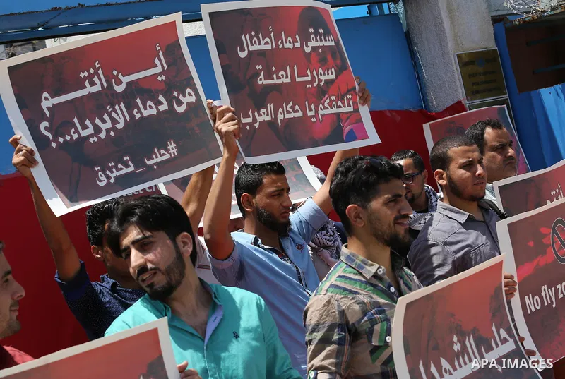 Palestinians hold placards during a rally against Syrian government shelling on the northern city of Aleppo, in front of the headquarter United Nation "UNSCO" in Gaza City, on May 2, 2016. Photo by Mohammed Asad