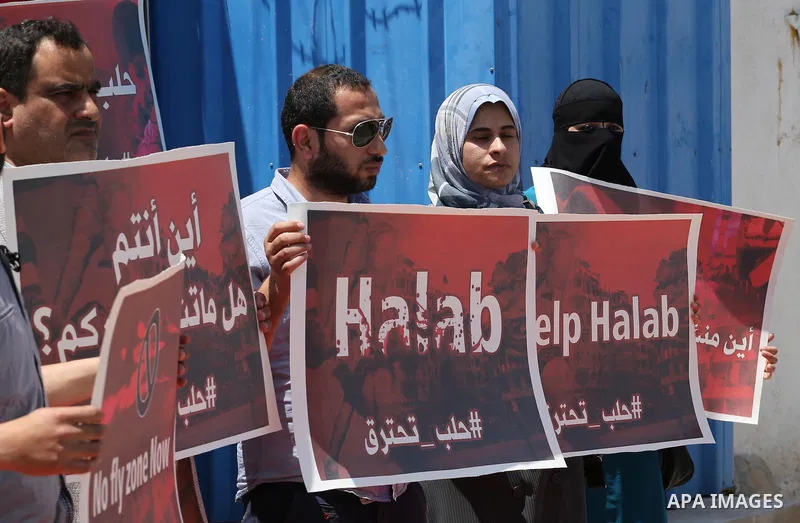 Palestinians hold placards during a rally against Syrian government shelling on the northern city of Aleppo, in front of the headquarter United Nation "UNSCO" in Gaza City, on May 2, 2016. Photo by Mohammed Asad