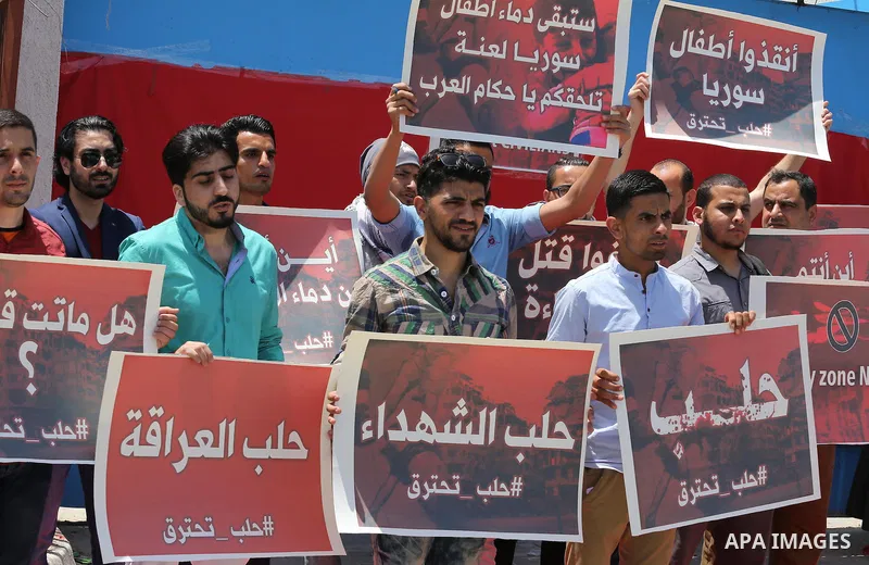 Palestinians hold placards during a rally against Syrian government shelling on the northern city of Aleppo, in front of the headquarter United Nation "UNSCO" in Gaza City, on May 2, 2016. Photo by Mohammed Asad