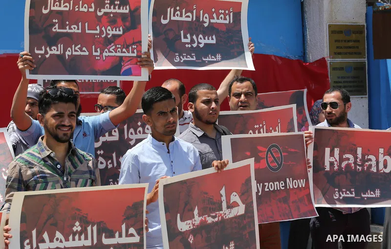 Palestinians hold placards during a rally against Syrian government shelling on the northern city of Aleppo, in front of the headquarter United Nation "UNSCO" in Gaza City, on May 2, 2016. Photo by Mohammed Asad